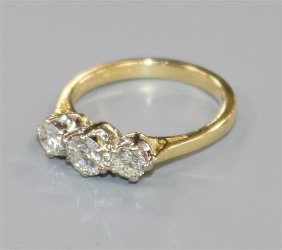 A modern 18ct gold and three stone diamond ring, size L.